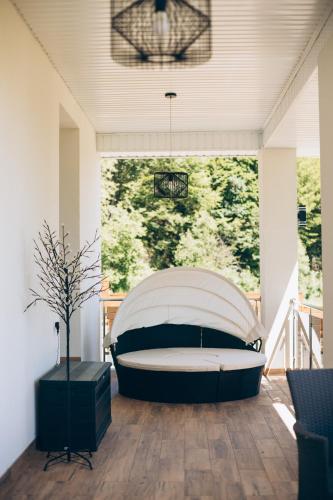 a bedroom with a large window with a bed on a porch at Апартаменти Helleborus in Staryy Mizunʼ