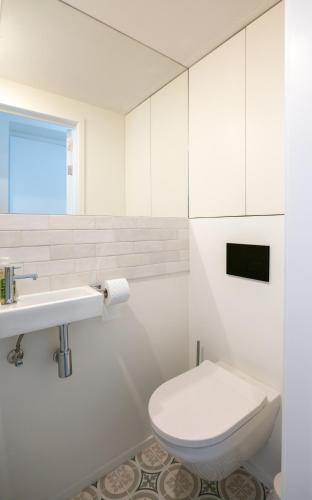 a white bathroom with a toilet and a sink at Les Camuches de la banque - Appartements privatifs de 35 à 110 m2 avec patios - Centre ville in Tournai