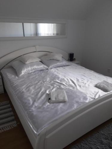 a white bed with a book on top of it at Noclegi u Beaty in Dubiecko
