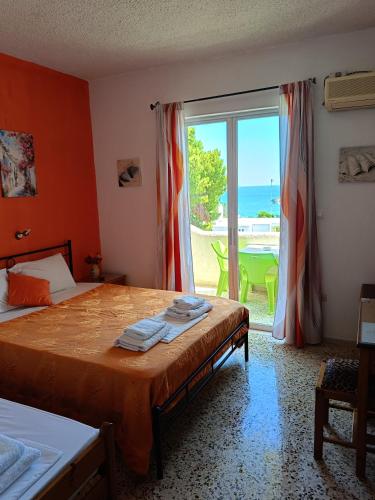 a bedroom with a bed with a view of the ocean at Eri Studios in Agia Marina Aegina
