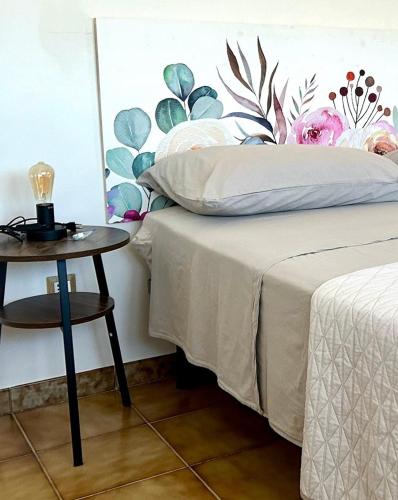 a bedroom with a bed and a table with a lamp at La Zia Acida Apartment in Ca Tiepolo