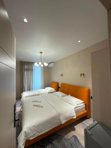 a bedroom with a large bed with white sheets at Our House in Kobuleti