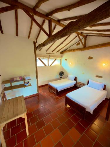 a large room with two beds and a table at Artepolis in Barichara