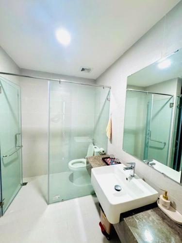 a bathroom with a sink and a glass shower at Rose Home in Lao Cai