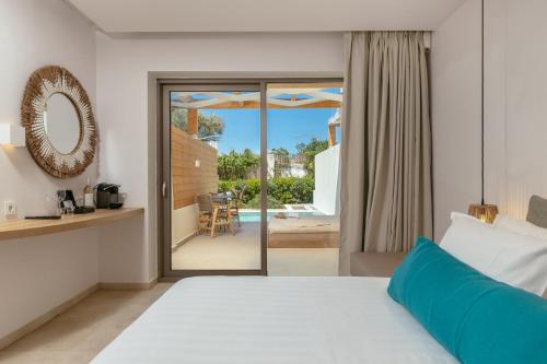 a bedroom with a bed and a view of a patio at Tsamis Zante Suites in Kypseli