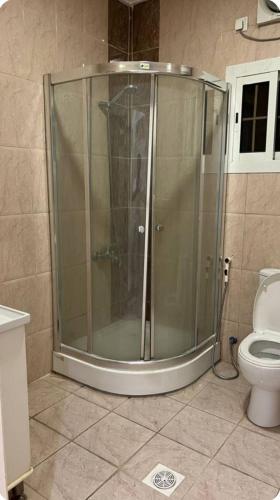 a glass shower in a bathroom with a toilet at hostel in Obhur in Jeddah