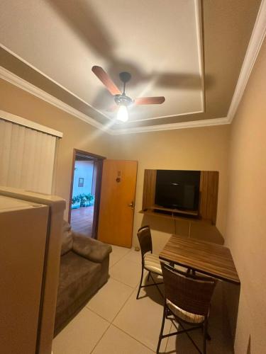 a living room with a ceiling fan and a table and chairs at Hotel Matrin in Barretos