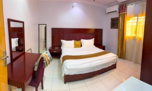 a bedroom with a large bed and a mirror at Al Samia economy apartment in Baljurashi