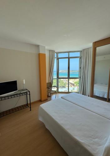 a bedroom with a bed and a view of the ocean at Hotel la Concha de Suances in Suances