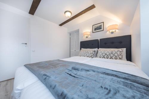 a bedroom with a large white bed with a black headboard at Heritage House in Klaipėda