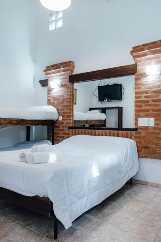 a bedroom with two beds and a tv on the wall at Hotel Del Parque in Corrientes
