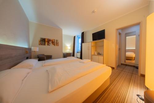 a bedroom with a large white bed in a room at Juno Hotel Bremen City in Bremen