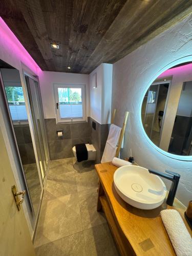 a bathroom with a toilet and a sink and a mirror at Bramberg Hideaway mit großer Terrasse in Größing
