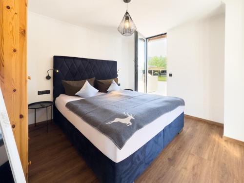a bedroom with a large bed with a blue blanket at Bramberg Hideaway mit großer Terrasse in Größing