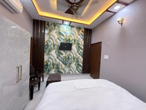 a bedroom with a bed and a ceiling fan at Hotel Drip inn JNK in Lucknow