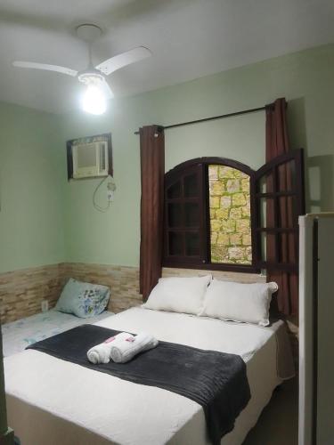a bedroom with two beds and a window at Recanto do sol in Mangaratiba