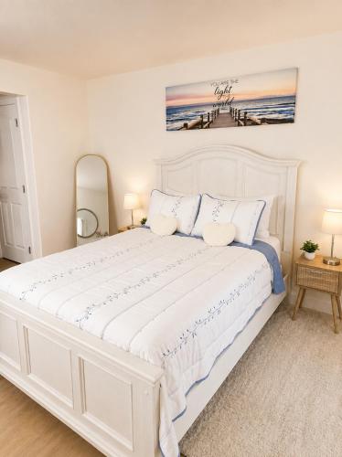 a white bedroom with a large white bed with pillows at The Caloosa Retreat in Fort Myers