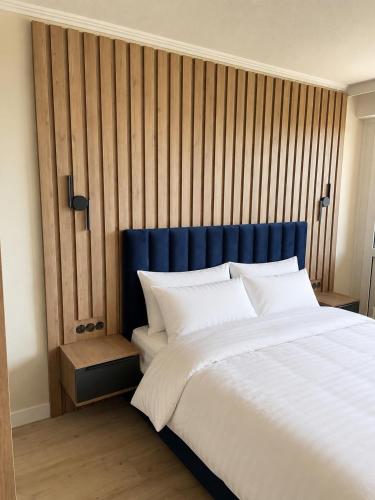 a bedroom with a large bed with a blue headboard at Nordsee-Hotel in Butjadingen