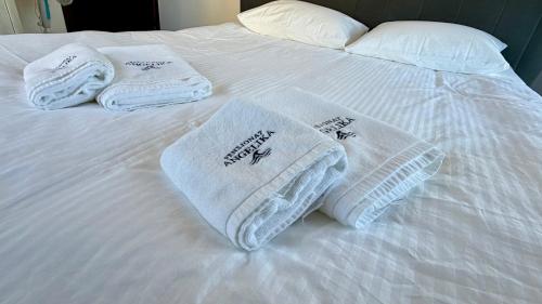 a white bed with towels on top of it at Angelika in Swarzewo
