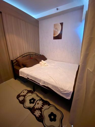 a small room with a bed with a white blanket at Casa Hiraya - Shore 2 Tower 2 in Manila