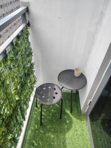 two tables on a balcony with a plant at Casa Hiraya - Shore 2 Tower 2 in Manila