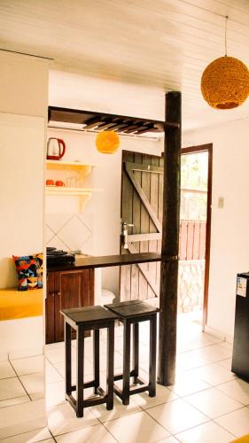a kitchen with a table and two benches in it at Pousada Aconchego do Rosa - Centrinho do Rosa in Praia do Rosa