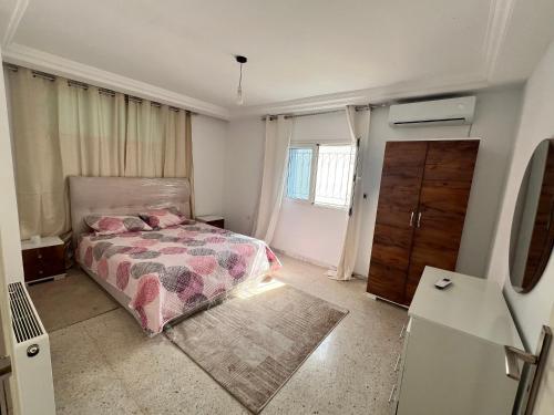 a bedroom with a bed and a dresser at Appartement 2 chambres à 250m de la plage, propre & bien équipé in Monastir