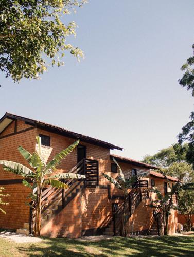 a brick house with a staircase leading up to it at Pousada Aconchego do Rosa - Centrinho do Rosa in Praia do Rosa