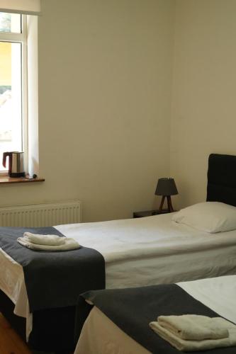 a bedroom with two beds and a window and a table at Hotel Lemi in Mestia