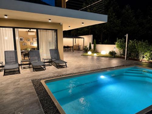 a swimming pool in the backyard of a house at Villa Perla di Draga in Mošćenička Draga