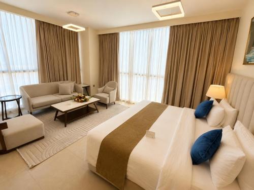 a hotel room with a large bed and a living room at Saray Deluxe Hotel Apartments in Abu Dhabi