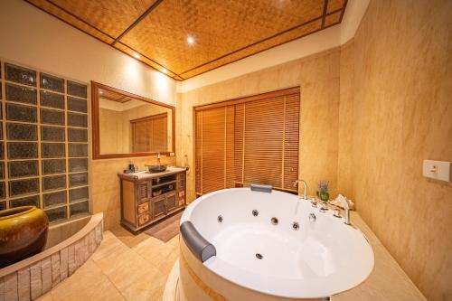 a large bathroom with a tub and a sink at Orchid House Pattaya, Totally Private Pool in Pattaya South