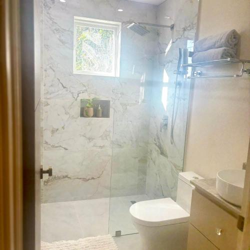 a bathroom with a shower with a toilet and a sink at Cazuria - by ZenBreak in Saint George