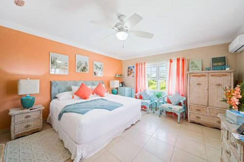 a bedroom with a large white bed and orange walls at Hidden Gem The Tropical - by ZenBreak in Christ Church