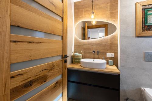 a bathroom with a sink and a mirror at LU-KA Apartamenty in Swornegacie