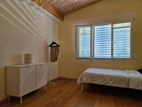 a bedroom with a bed and a window with shutters at Villa dolce vita in Murten