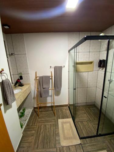 a bathroom with a shower with a glass door at Hotel Sinhá in Tianguá