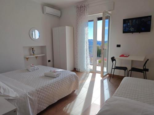 a bedroom with two beds and a table and a balcony at Nirvana Bed and Breakfast Experience in Noepoli
