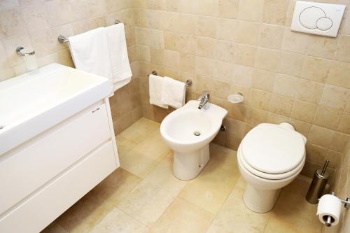 a white bathroom with a toilet and a sink at Appartamenti le Conchiglie 1 by Ferrocino Holiday in Lido Conchiglie