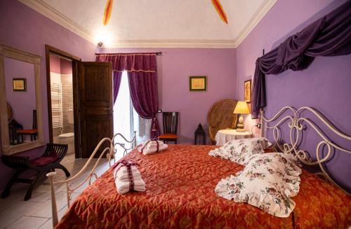a bedroom with a large bed with purple walls at Palazzo Diamante in Calascio