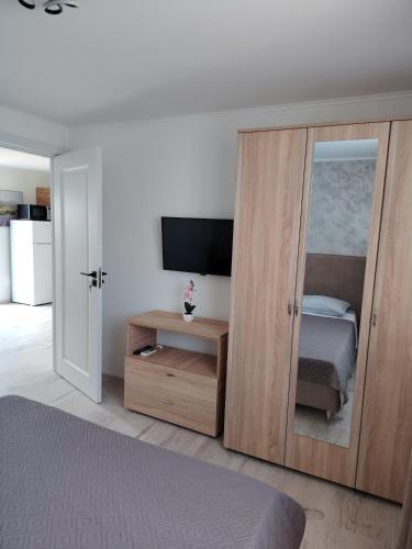 a bedroom with a sliding glass door with a television at Casa Joe in Corbu