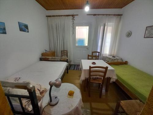 a bedroom with two beds and a table and chairs at ΑΝΝΑ'S Πύργος - ΣΑΜΟΣ in Pýrgos