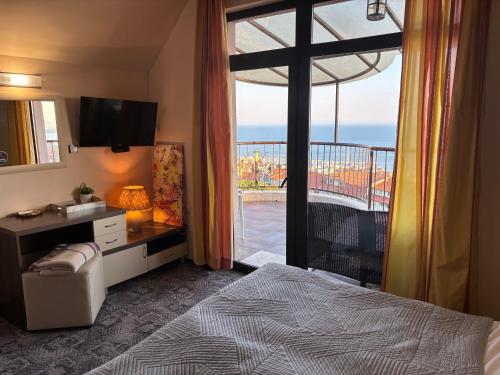 a bedroom with a bed and a window with a balcony at Vila Vista Вила Виста in Sveti Vlas