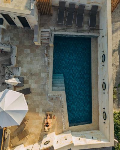 an overhead view of a swimming pool with a person sitting in a chair next to at Mare Cappadocia Adults Only in Göreme