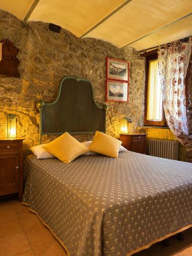 a bedroom with a bed in a stone wall at La Rocca Sospesa - Castello in Apricale