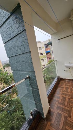 a balcony of a building with a glass wall at Hill View Haven in Rushikonda
