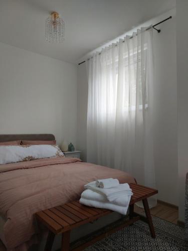 a bedroom with a bed with towels on a bench at Secret Garden House in Surduk