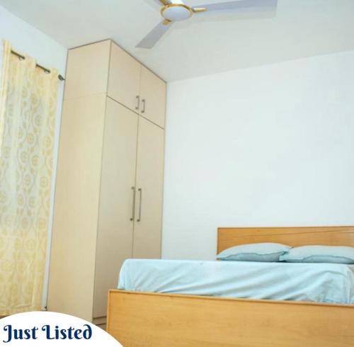 ein Schlafzimmer mit einem Bett und einem weißen Schrank in der Unterkunft Omane Homes in Cape Coast