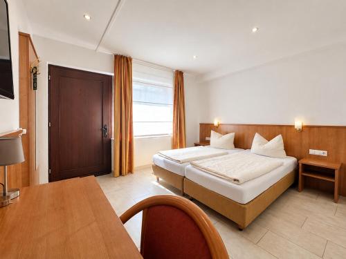 a hotel room with a bed and a desk and a room at Hotel Kaiserhof in Lehrte