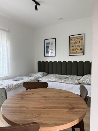 a room with two beds and a wooden table at Pokoje U rybaka in Stężyca